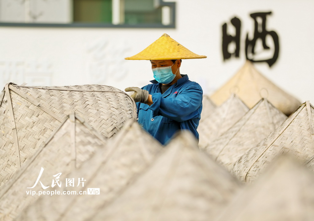 2024年9月21日，山东滕州市一家酱醋食品有限公司的工人在晾晒场上浇淋晒制酱油。