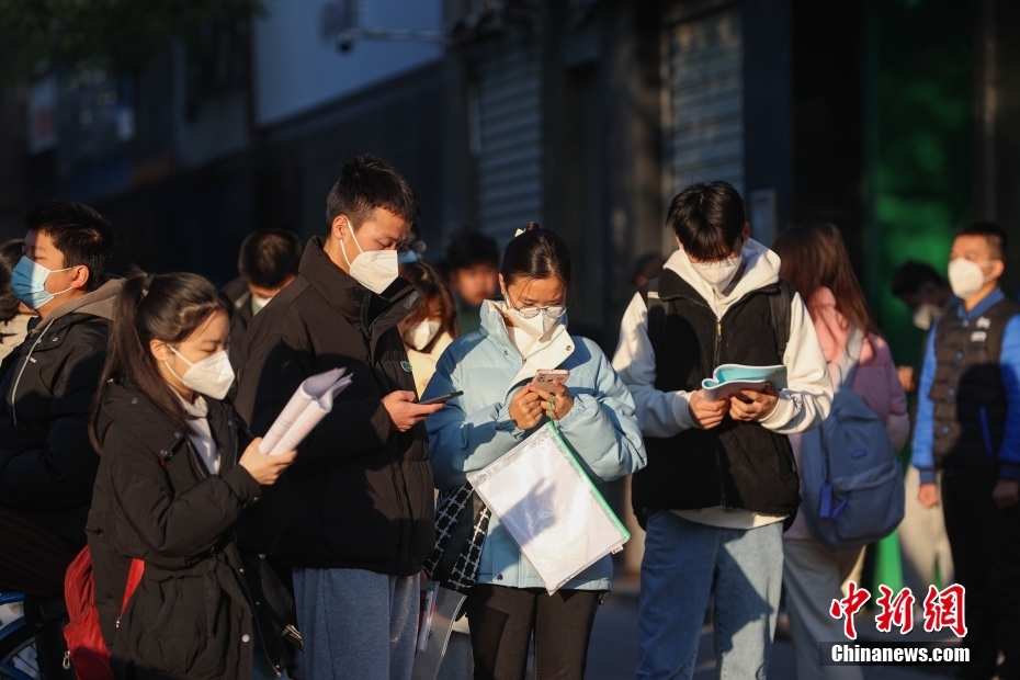 1月8日，江西南昌市第二十八中学考点外，几名考生在复习。当日，中央机关及其直属机构2023年度考试录用公务员公共科目笔试举行。<a target='_blank' href='/'>中新社</a>记者 刘力鑫 摄

