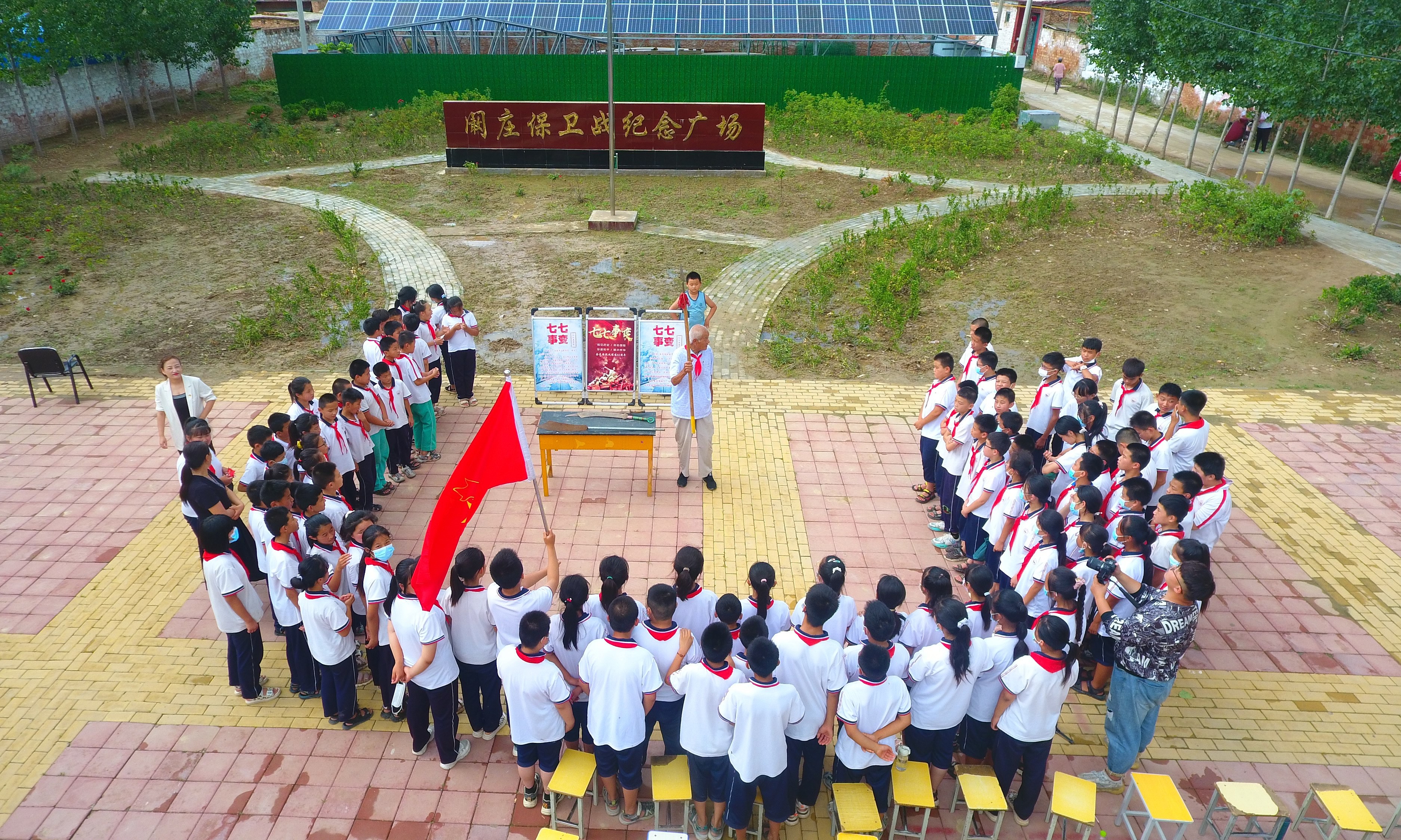 2022年7月6日，山東省聊城市，在茌平區(qū)菜屯鎮(zhèn)闞莊村的闞莊保衛(wèi)戰(zhàn)紀(jì)念廣場，闞莊保衛(wèi)戰(zhàn)親歷者王光木老人，為小學(xué)生們講述抗戰(zhàn)故事，展示大刀、長矛。