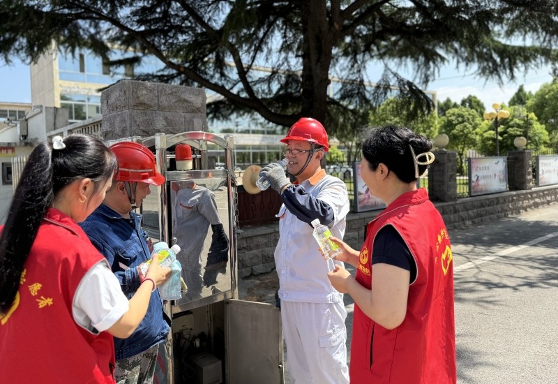 “暖心物供”志愿服务者为维修电动大门的职工送上矿泉水---图片提供崔雅娟_副本