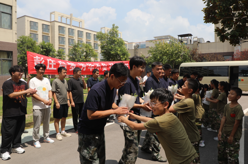 职工子女给大学生献花.PNG